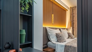 A modern bedroom with a bed, bedside table, and a shelf with decorative items.