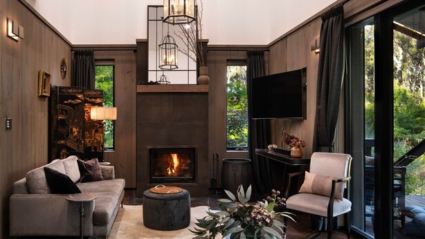 Una sala de estar moderna con chimenea, un sofá, una silla y un televisor.