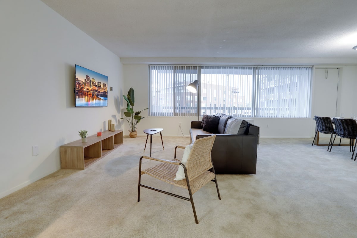 Una sala de estar moderna con un sofá, una silla, una mesita y un cuadro en la pared.