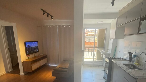 Een modern appartement met een woonkamer, keuken en balkon.