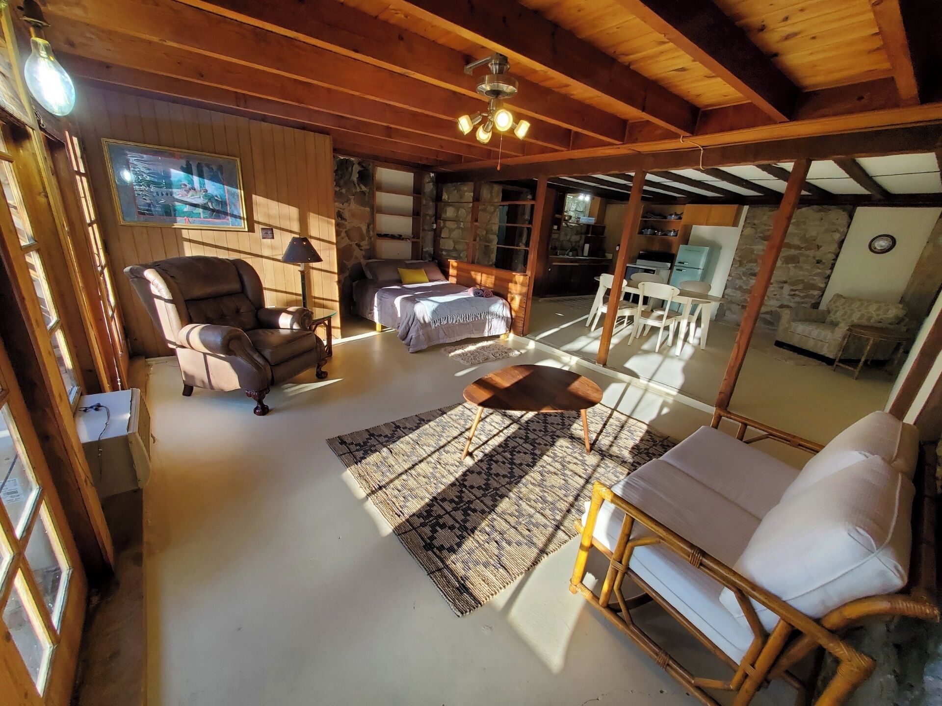 Una sala de estar acogedora con un sofá, un sillón y un comedor con mesa y sillas.