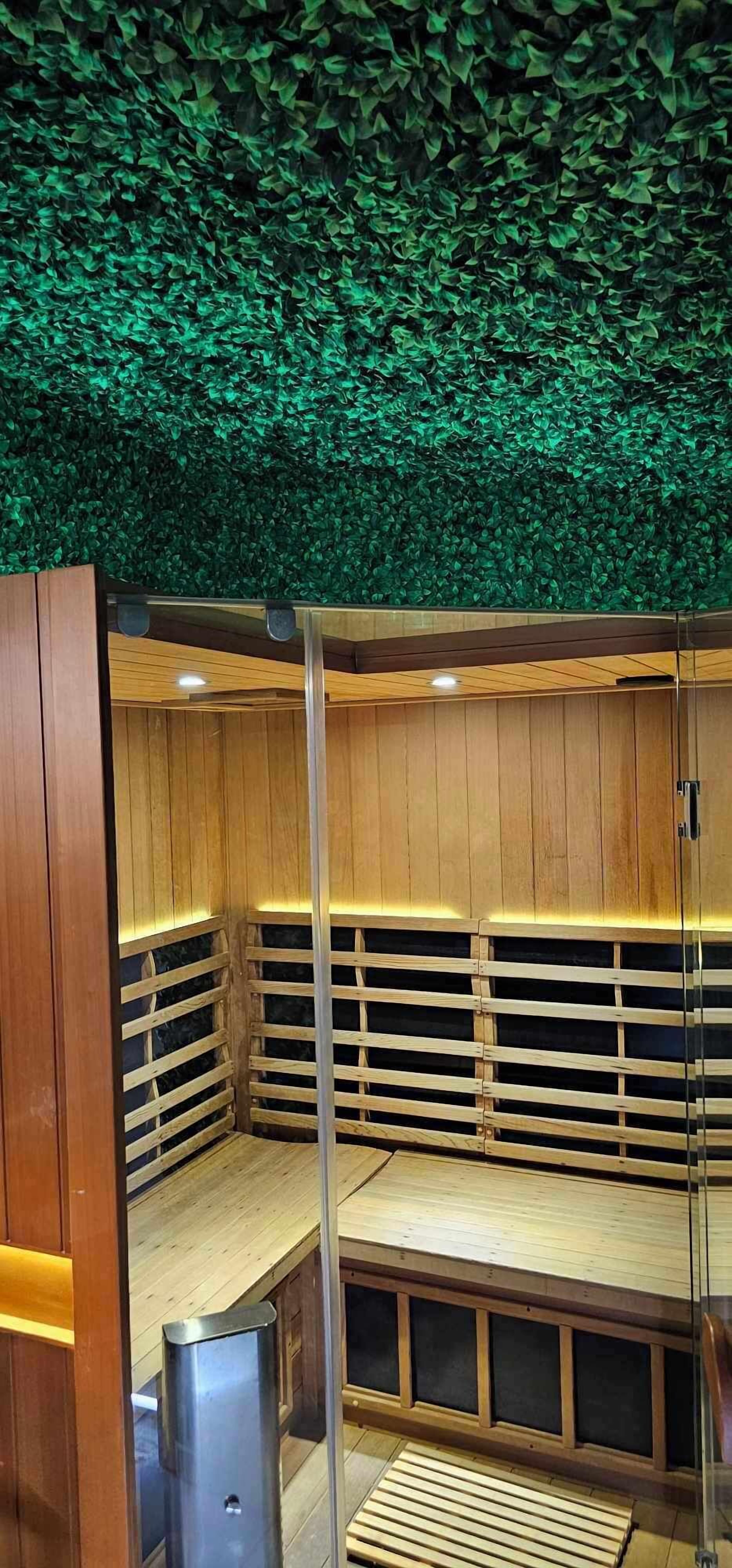 A sauna with wooden walls and a green leaf-covered ceiling.