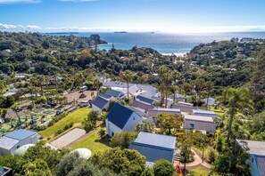 Uma área residencial com casas, um campo de golfe e vista para o oceano.