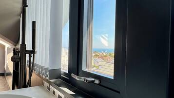 Un baño moderno con una bañera grande, una ventana con vista a la ciudad y un perchero para toallas.