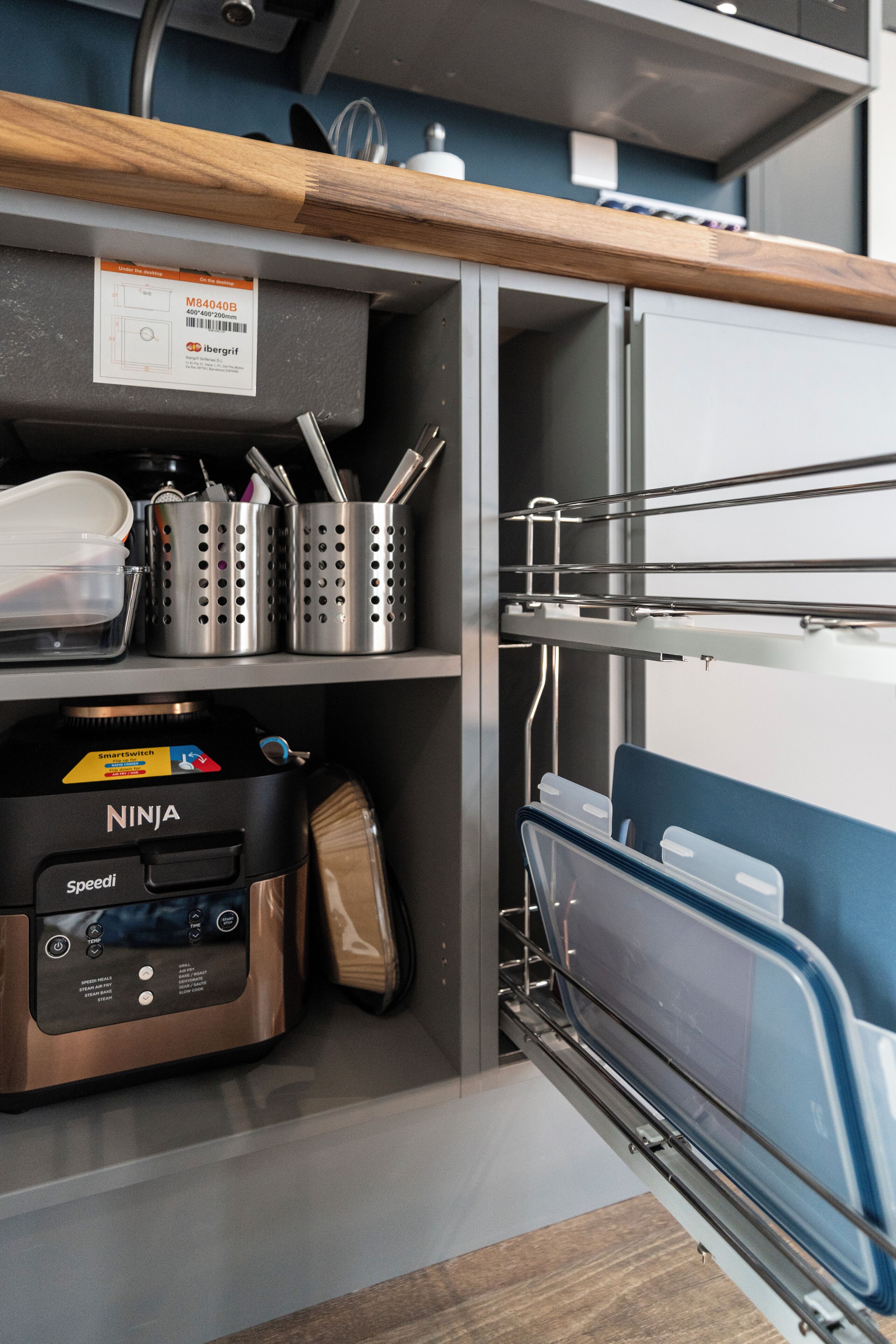 A kitchen with a built-in oven, a coffee maker, and a dish rack.
