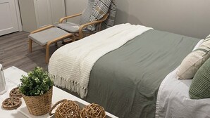 A bedroom with a bed, a chair, a dresser, and a window. -  Gertie's Nook: Charming Private Studio Space close to everything! (Dartmouth)