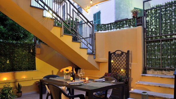 Ein Essbereich mit Tisch für zwei Personen, einer Treppe und Blick auf den Garten.