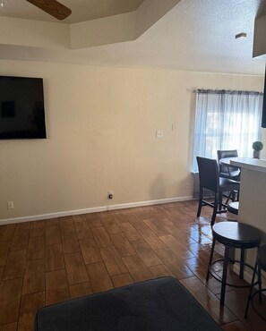 Relax in this serene space with a high ceiling, flat-screen TV, and dining area.