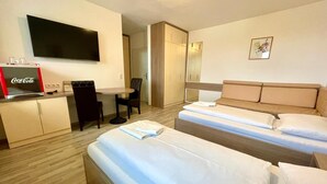 A hotel room with two beds, a desk, a chair, a television, and a Coca-Cola refrigerator. - Apart Hotel Neudörfl (Neudoerfl)