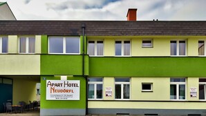 A two-story building with a green and yellow facade, labeled as 'Apart Hotel Neudörfl'. - Apart Hotel Neudörfl (Neudoerfl)