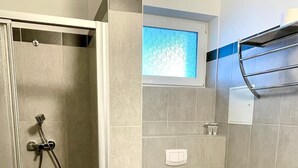 A bathroom with a shower, toilet, and a window. - Apart Hotel Neudörfl (Neudoerfl)