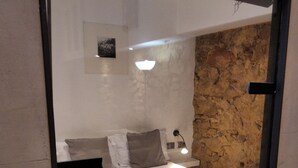 A bedroom with a bed, pillows, a bedside lamp, and a mirror. - MONUMENT, large, cosy apartment (Barcelona)
