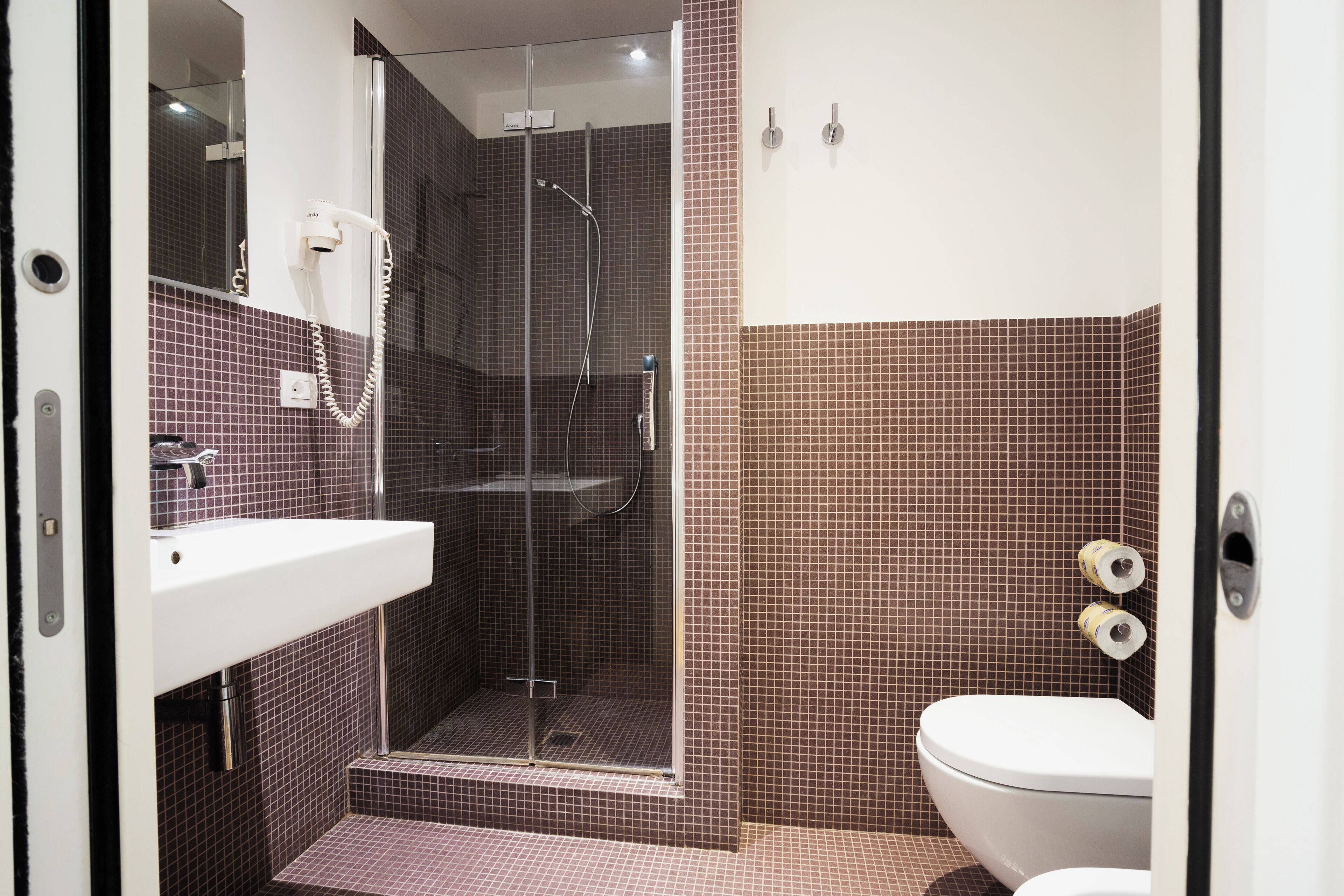 A bathroom with a shower, toilet, and sink.