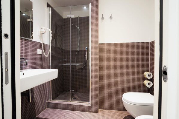 A bathroom with a shower, toilet, and sink. - History Suite Essence (Rome)
