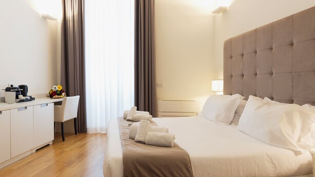A hotel room with a bed, a desk, and a chair. - History Suite Essence (Rome)