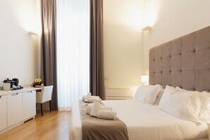 A hotel room with a bed, a desk, and a chair. - History Suite Essence (Rome)