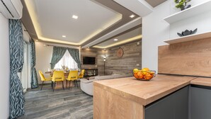 A modern kitchen with a wooden countertop and a fruit bowl.