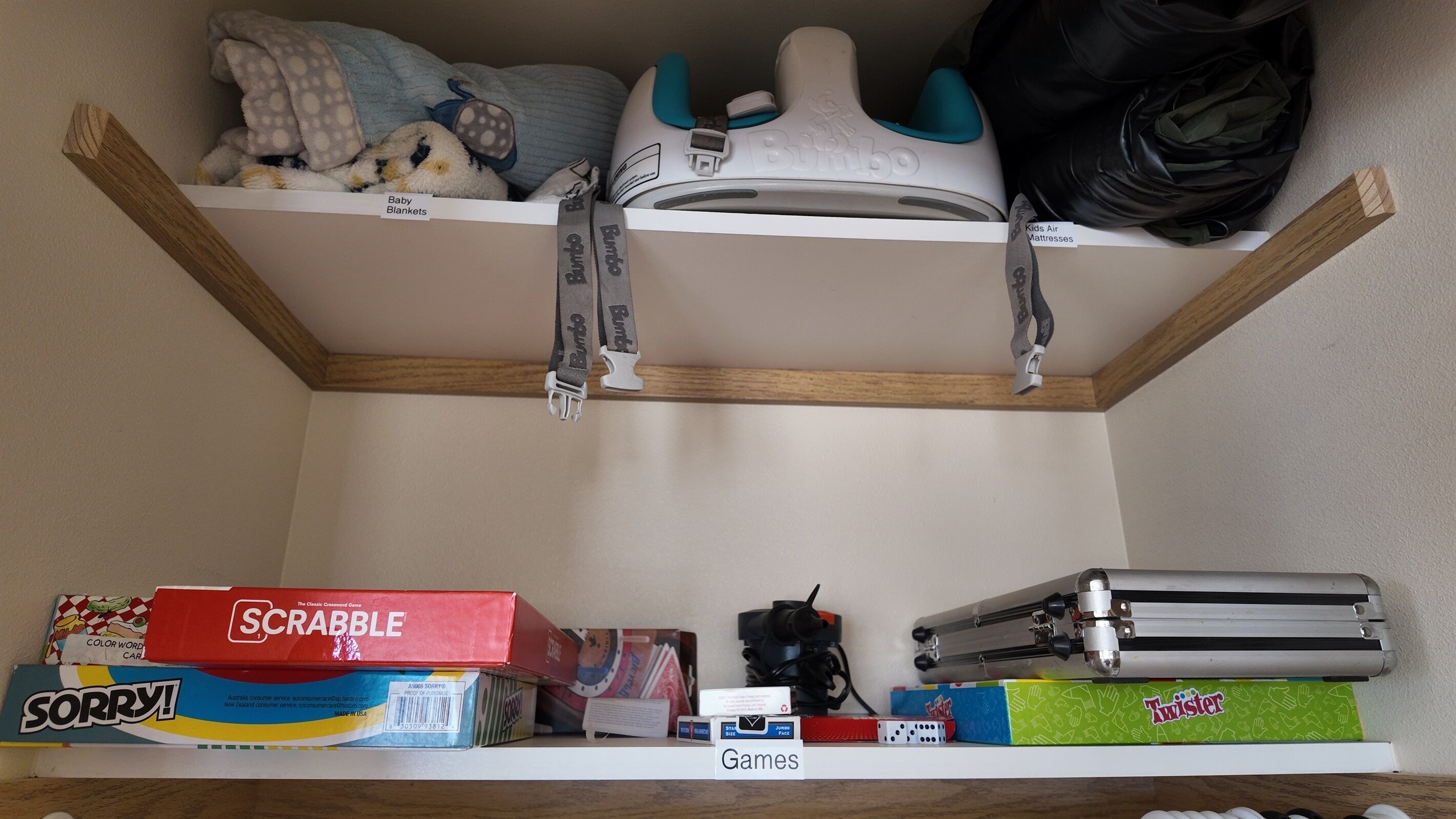 A storage area with shelves containing baby blankets, children's air mattresses, and various board games.