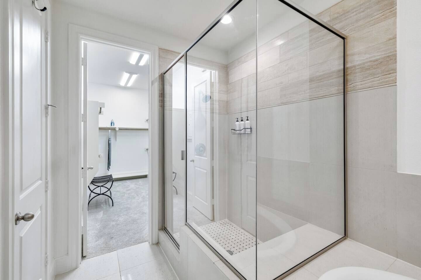 Een moderne badkamer met een douchecabine van glas, een toilet en een wastafel.