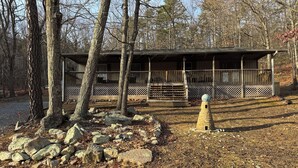 A cabin with a wooden deck, surrounded by trees and rocks. - Relax at Skylark's Nest (McGaheysville)
