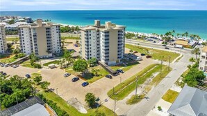 A high-rise building with a parking lot and a view of the ocean.