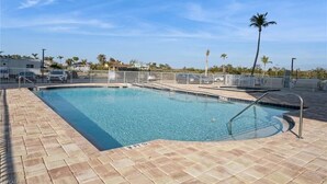A rectangular swimming pool with a 3 FT depth marker, surrounded by a paved deck and a white fence.