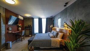 Een moderne slaapkamer met een bed, nachtkastje en een grote kamerplant.
