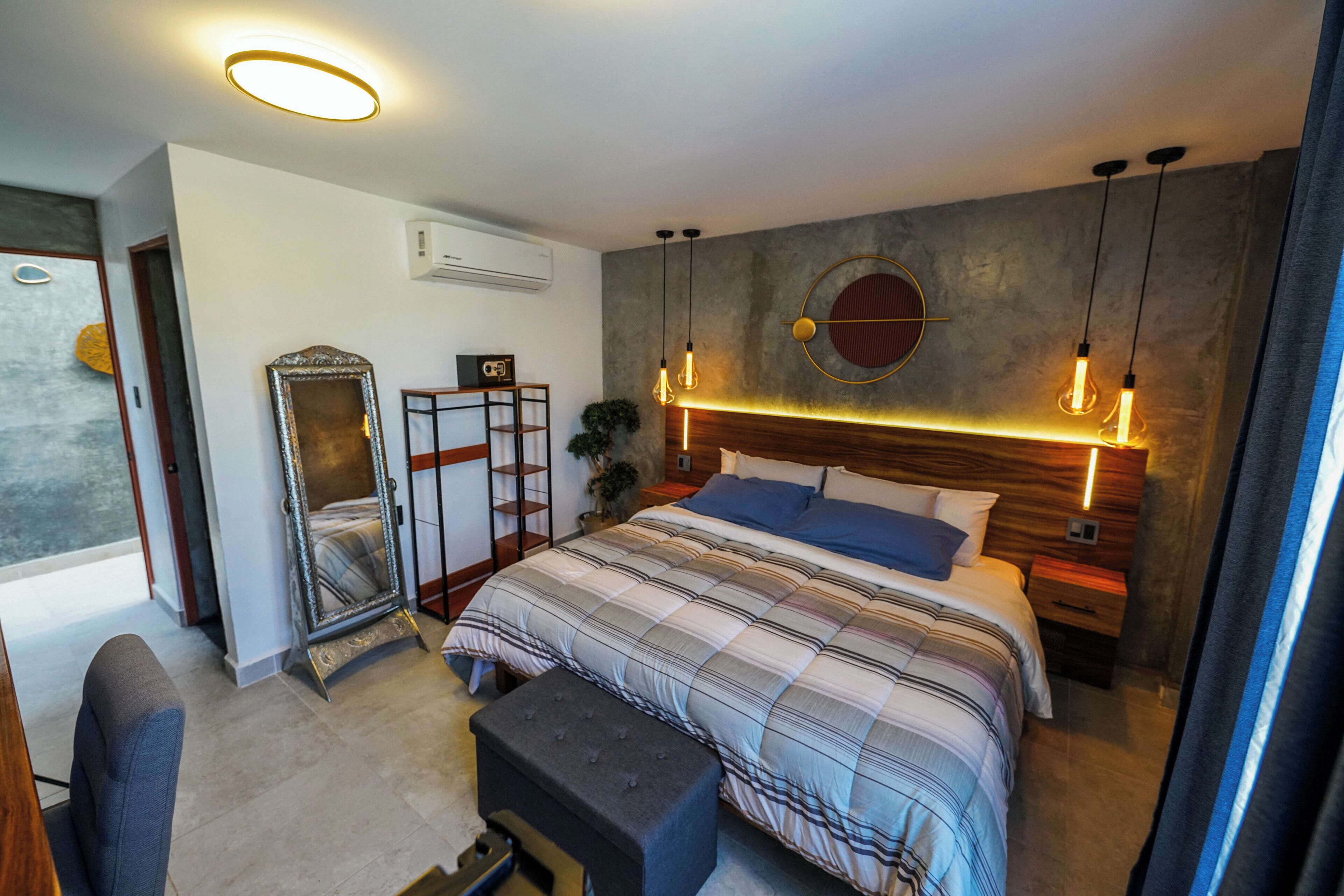 Um quarto moderno com uma cama grande, mesas de cabeceira, um espelho e um design de parede único.