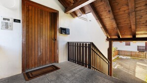 A wooden door, a metal mailbox, and a stone staircase leading to an outdoor area.