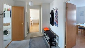 A hallway with a bench, a coat rack, and a door leading to a room. - 2 bedroom nice apartment in Hyltebruk (Hyltebruk)