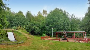 A playground with a slide, a swing set, and a covered seating area surrounded by trees. - 2 bedroom nice apartment in Hyltebruk (Hyltebruk)