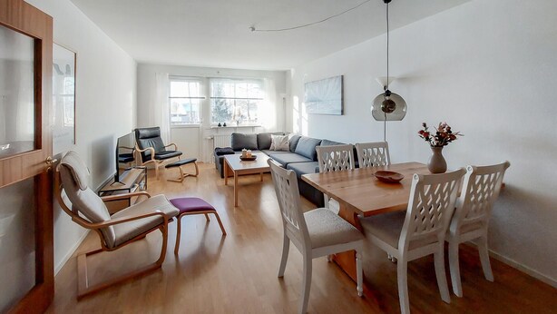 A modern living room with a wooden dining table, white chairs, a sofa, and a coffee table. - 2 bedroom nice apartment in Hyltebruk (Hyltebruk)