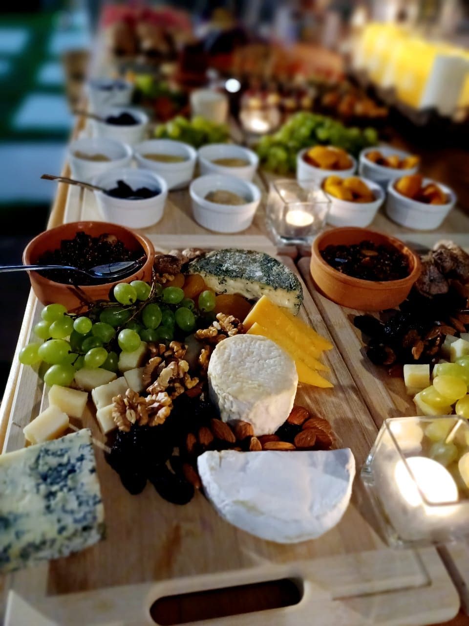 Una tabla de quesos con diferentes tipos de queso, frutas y frutos secos.
