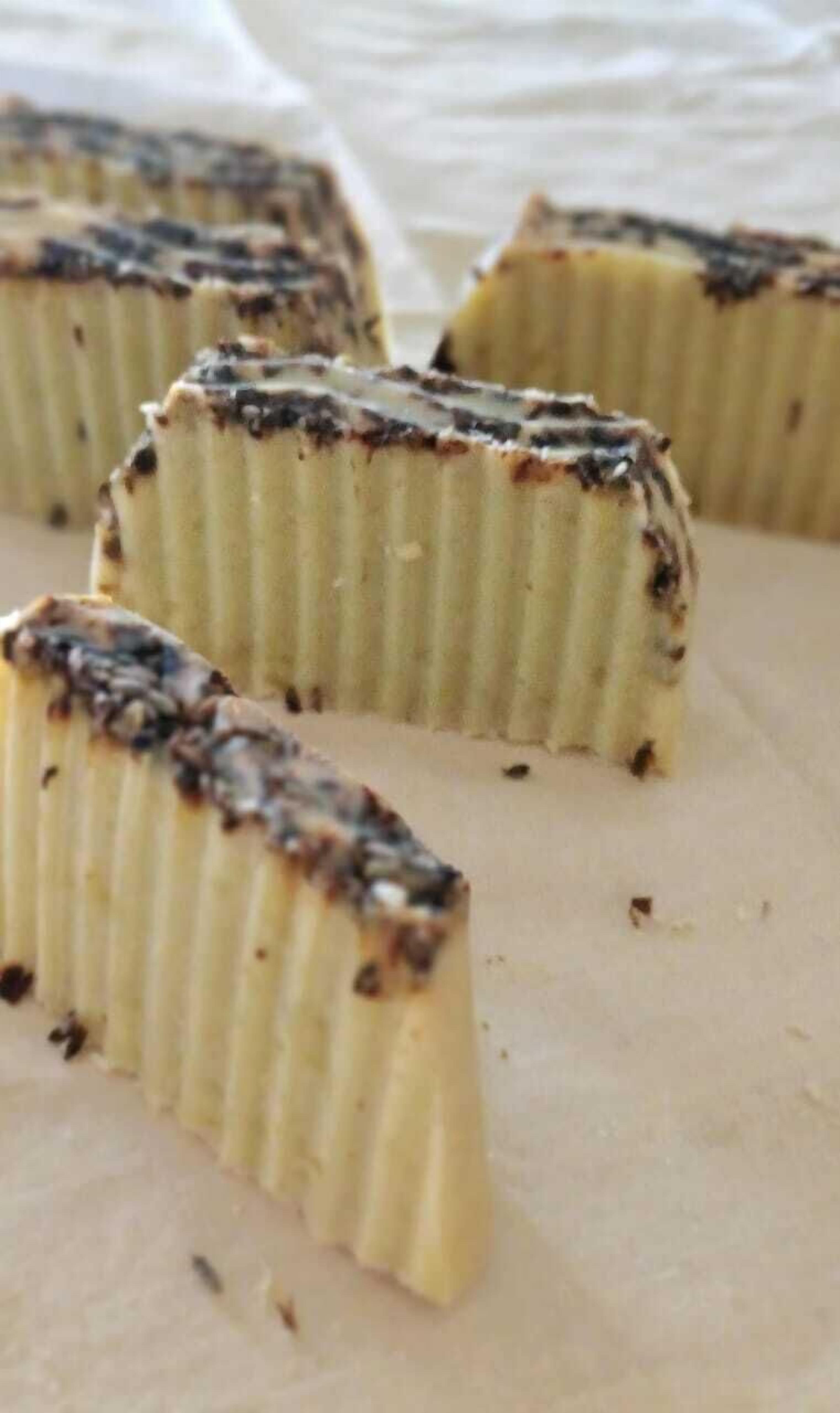 Primer plano de un postre con textura cremosa y cobertura oscura, posiblemente chocolate o caramelo.