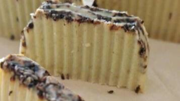 Primer plano de un postre con textura cremosa y cobertura oscura, posiblemente chocolate o caramelo.
