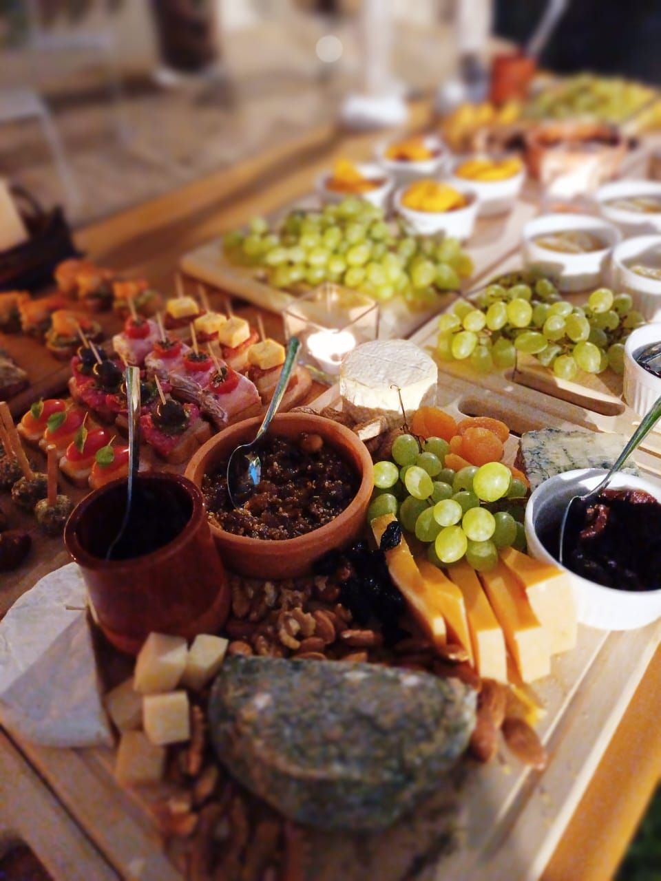 A charcuterie board with various cheeses, fruits, and nuts.