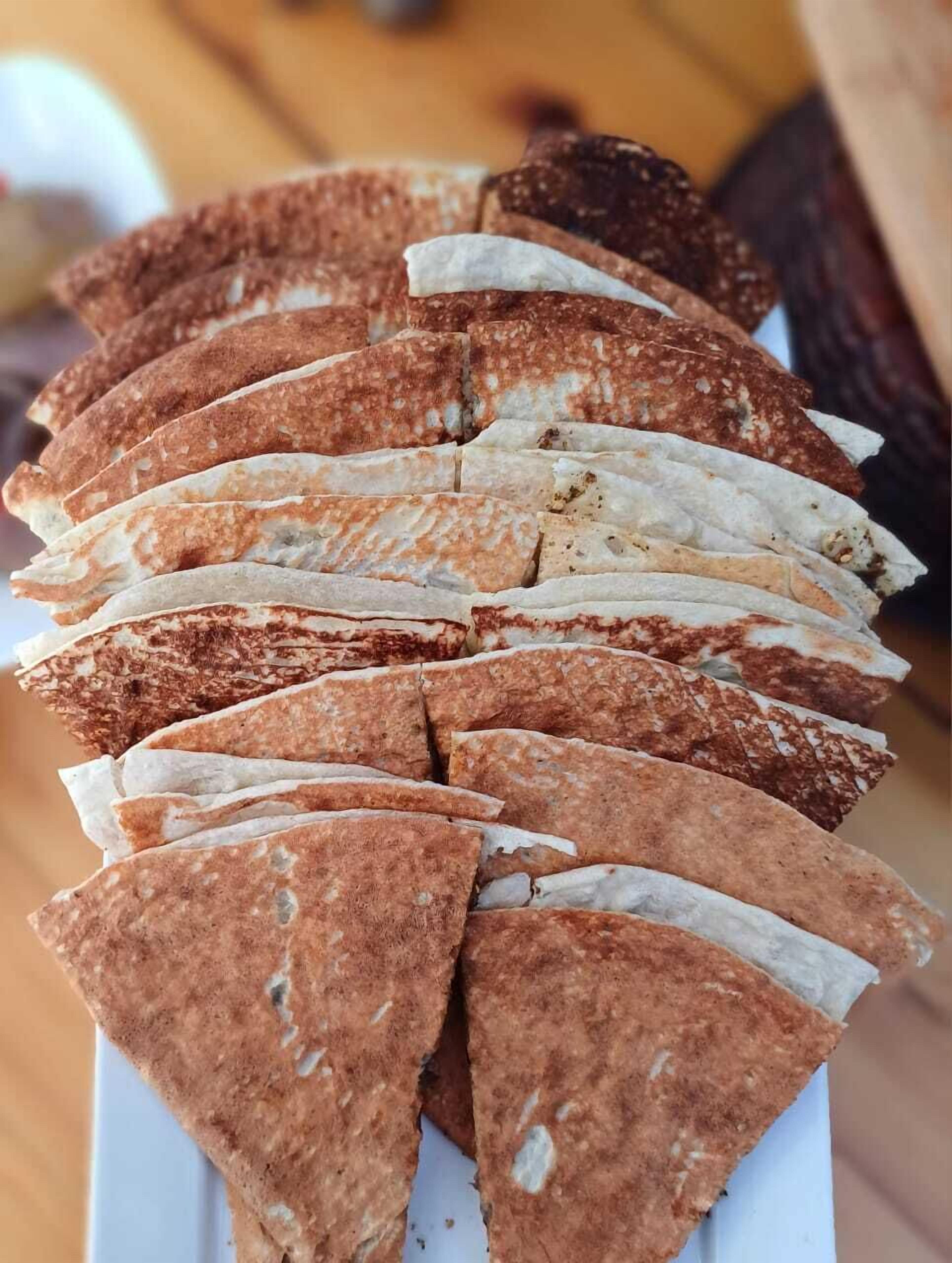 A stack of flatbreads on a white plate.