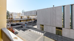 Un bâtiment moderne avec une enseigne indiquant « CONFÉRENCE » et un espace de stationnement où sont garées des voitures.