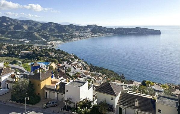 A coastal town with Mediterranean-style buildings, a clear view of the sea, and a hilly landscape in the background. - 4 bedroom gorgeous home in Almuñecar (Almuñecar)