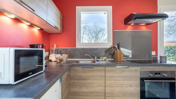 A modern kitchen with a microwave, oven, and sink.