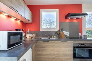 A modern kitchen with a microwave, oven, and sink.