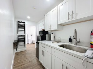 Fridge, microwave, coffee/tea maker, cookware/dishes/utensils