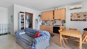 Ein kompakter Wohnbereich mit Sofa, Esstisch und Küchenzeile.
