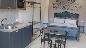 A compact bedroom with a bed, a small table, and a chair. - Apartment 'Fede's Home' with Private Terrace, Wi-Fi and Air Conditioning (Fiumicino)