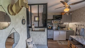 Un espace de vie compact comprenant une kitchenette, un coin repas et une chambre.