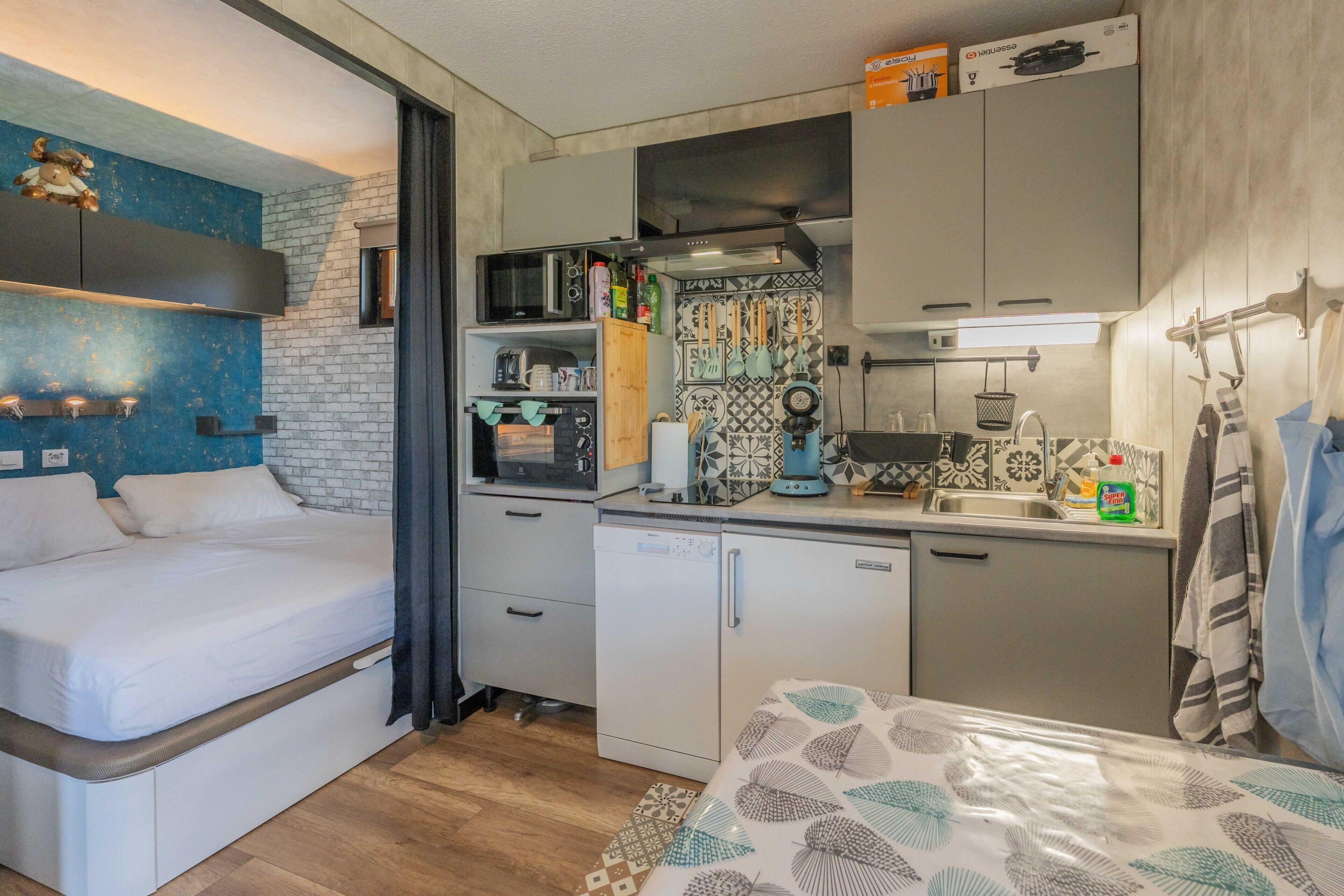 A compact kitchenette with a microwave, coffee maker, and a small refrigerator.