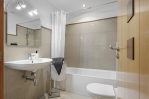 Ein Badezimmer mit Waschbecken, Toilette, Badewanne und Dusche.