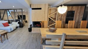 Een moderne woonkamer met een bank, salontafel en een open haard.