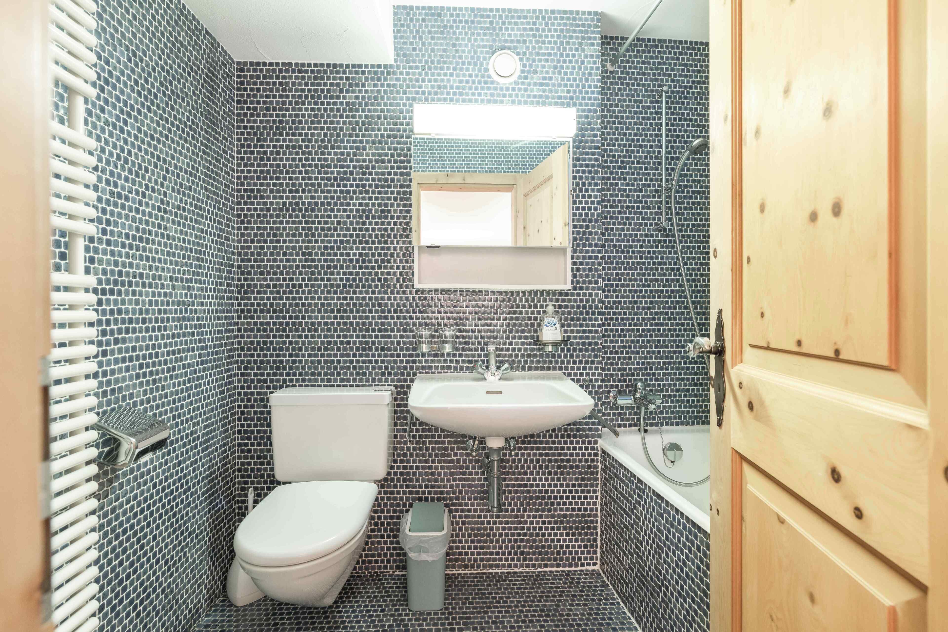 A small bathroom with a toilet, sink, and mirror.