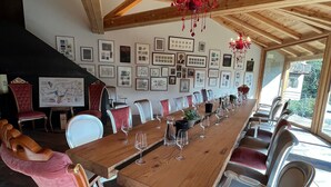 Un comedor con una larga mesa de madera, sillas y una lámpara de araña.